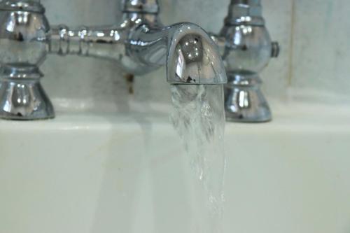 a sink with water coming out of a faucet at Spacious & Comfortable 3 Bedroom House - FREE WiFi & FREE Parking in Killingbeck