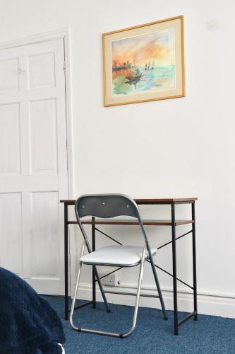 a chair sitting in front of a desk at Spacious & Comfortable 3 Bedroom House - FREE WiFi & FREE Parking in Killingbeck