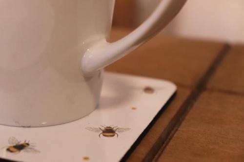 a cup with three bees on it sitting on a table at Spacious & Comfortable 3 Bedroom House - FREE WiFi & FREE Parking in Killingbeck