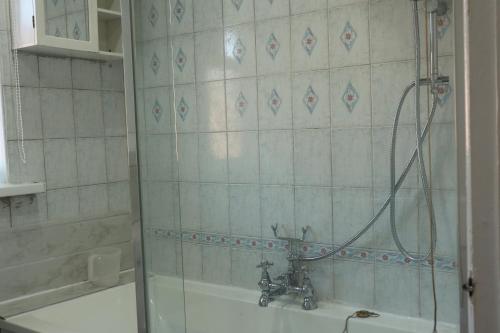 a bathroom with a shower with a tub and a sink at Spacious & Comfortable 3 Bedroom House - FREE WiFi & FREE Parking in Killingbeck