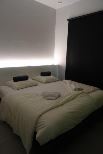 a bedroom with a large bed with two pillows on it at JustUs in Ypres