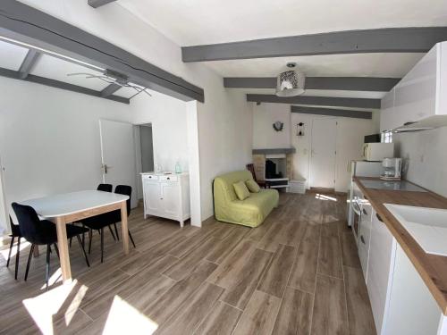 a kitchen and living room with a table and a dining room at Maison bord de lac de charmes in Bannes