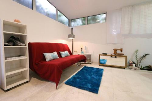 a living room with a red couch and a blue rug at Val & Mar Studio Apartment in Zadar