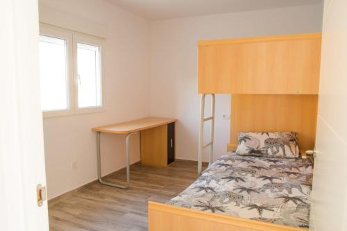 1 dormitorio con cama, escritorio y ventana en Casa O Souto, en Mazaricos