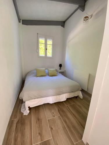 une chambre avec un lit et un parquet dans l'établissement Maison bord de lac de charmes, à Bannes