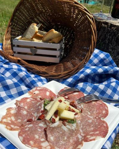 a plate of food on a table with a basket of food at LOCANDA PODERE LE VIGNE in Radda in Chianti