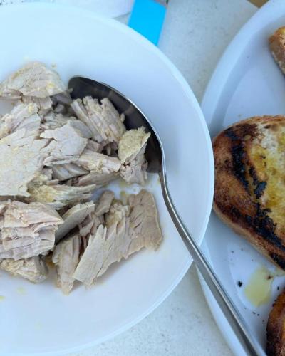a plate of food with meat and bread and a spoon at LOCANDA PODERE LE VIGNE in Radda in Chianti