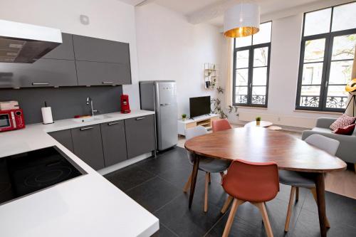 een keuken met een houten tafel en een eetkamer bij Les Cerisiers - Appart de Standing à Namur Centre in Namen
