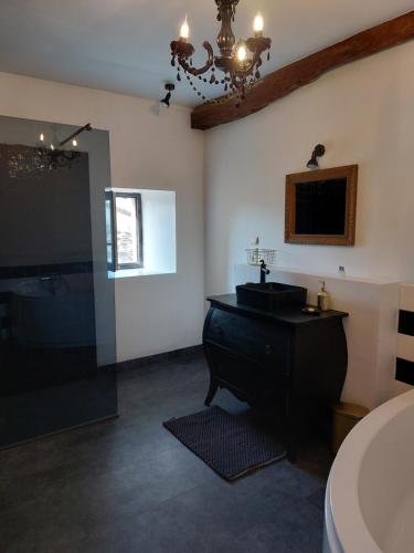 a bathroom with a black sink and a mirror at L'Appartement de la MAISON BLEUE in Villeréal