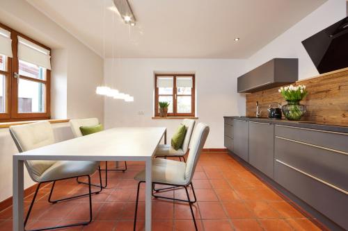 - une cuisine avec une table et des chaises dans la chambre dans l'établissement Alpinlife Chalet, à Bad Kohlgrub
