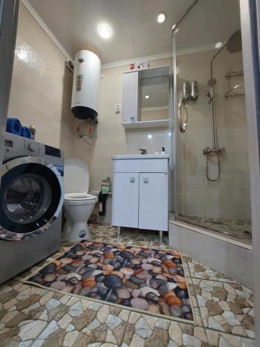 a bathroom with a washing machine and a toilet at У моря in Aktau