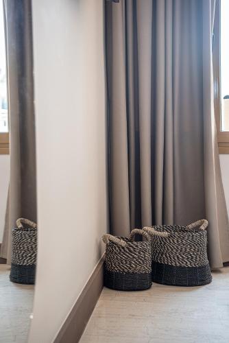 three baskets sitting on the floor in front of a curtain at Esperides Beach Hotel Apartments in Stalos