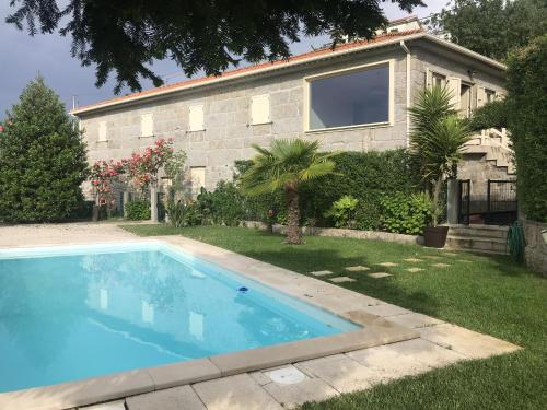 a swimming pool in front of a house at Charming Villa in Resende with Private Pool in Resende