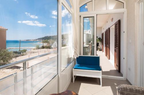 una sedia blu su un balcone con vista sull'oceano di Terra Beach Apartment a Duće