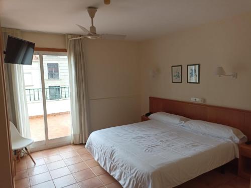1 dormitorio con 1 cama, TV y ventana en Hotel Marycielo, en Sanxenxo