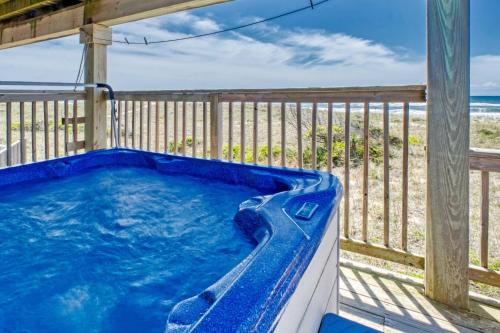 a hot tub on a deck with the beach at Happiness on the Beach in Frisco