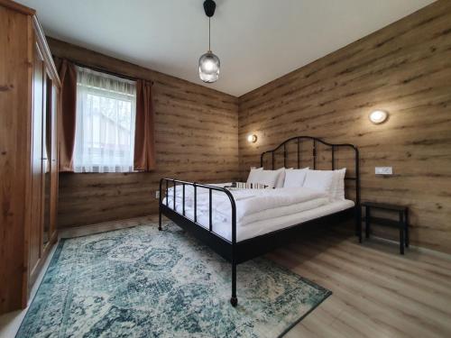 1 dormitorio con 1 cama en una habitación con paredes de madera en Harmónia faházak, en Bogács