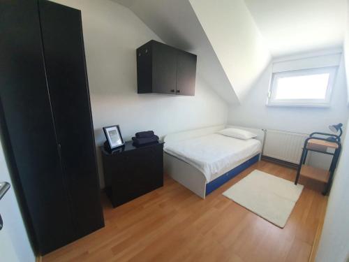 a small bedroom with a bed and a cabinet at Apartment Lily near Zagreb airport in Velika Gorica