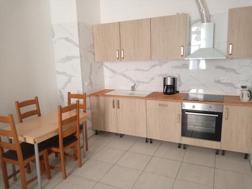 - une cuisine avec des placards en bois, une table et un évier dans l'établissement T2 neuf Sète centre ville, à Sète