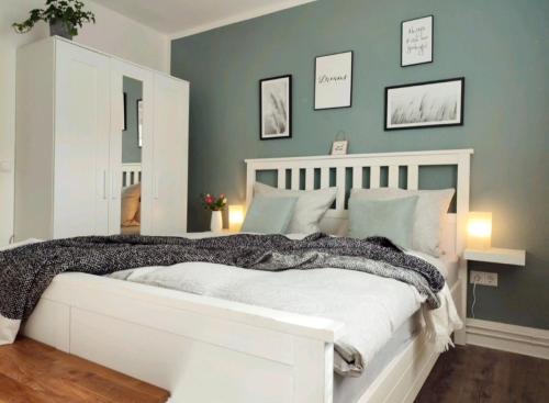 a bedroom with a white bed with green walls at Naturnahe FeWo zwischen Meer&Seen bei Kiel in Schwentinental