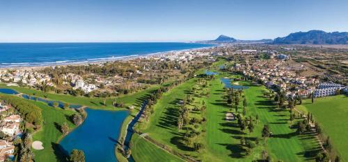 einen Luftblick auf einen Golfplatz neben dem Meer in der Unterkunft Blue Oliva Nova MET & Golf in Oliva