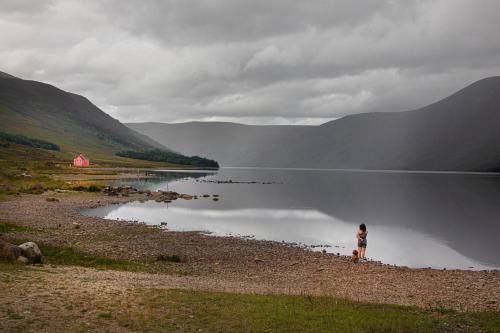 a woman standing on the shore of a lake at Cuillich Mill Bed and Breakfast in the Highlands in Alness