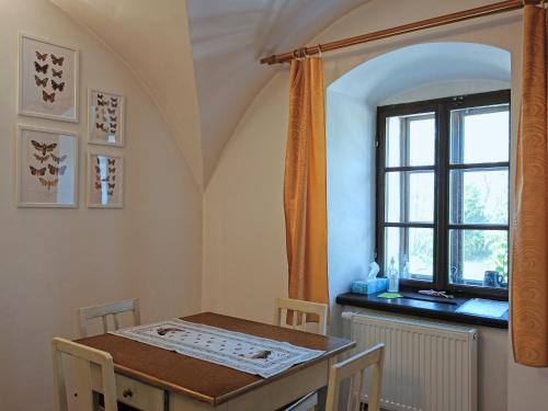 a dining room with a table and a window at Apartmány v broumovském statku in Broumov