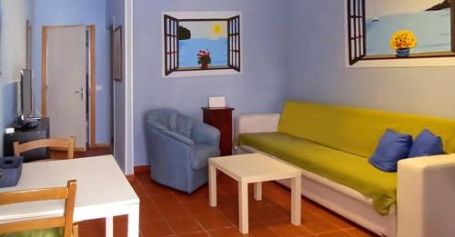 una sala de estar con un sofá y una silla en Porta Di Ferro al centro storico, en Gaeta