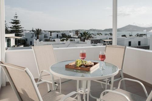 a table with two glasses of wine and a box of fruit at Sea View Casa in Naxos Chora