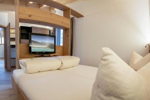a living room with a couch and a tv at ROSENHOF- Premium & Landhaus Apartments & Wellness & Erlebnisbauernhof in Nauders