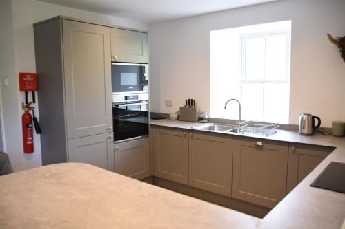 a kitchen with a sink and a stove top oven at The Gardeners Cottage in Pitlochry