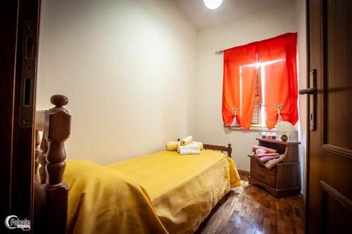 una camera con letto giallo e finestra rossa di La Pergola del Grottino a Torgiano