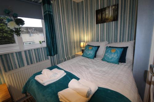 a bedroom with a bed with two towels on it at Aspley House in Sutton in Ashfield