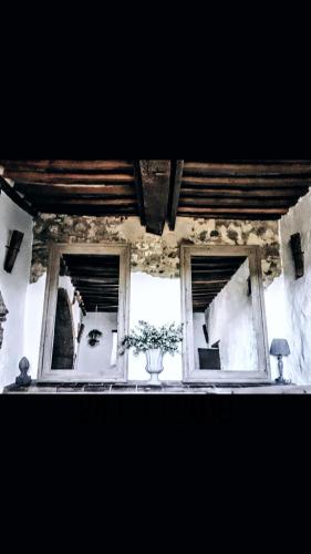 a room with two windows and a vase of flowers at Podere Pievina Delle Corti - Dimora di Campagna in Sinalunga