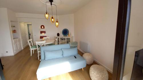 a living room with a blue couch and a table at SonhosQrodopiam Praia da Barra in Praia da Barra