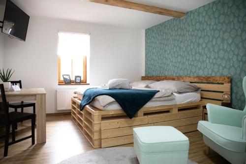 a bedroom with a bed and a desk and a chair at Joy Aparthotel Keilberg in Klínovec