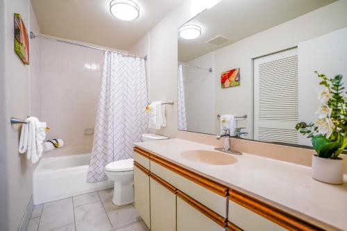 a bathroom with a sink and a toilet and a tub at Hale Moi #103A in Princeville