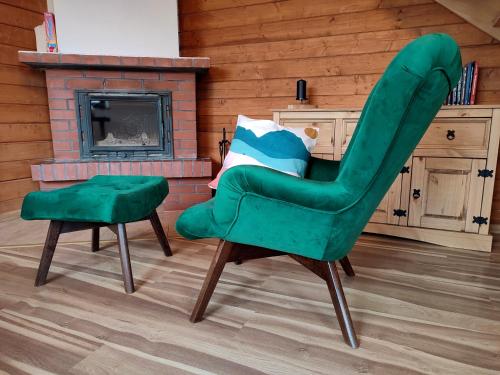 a green chair and stool in a room with a fireplace at Łemkowska Izba in Wysowa-Zdrój