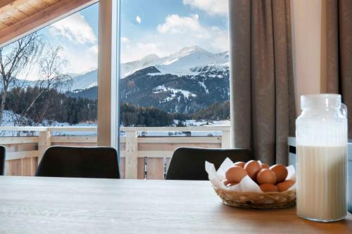 a table with a bowl of eggs and a bottle of milk at ROSENHOF- Premium & Landhaus Apartments & Wellness & Erlebnisbauernhof in Nauders