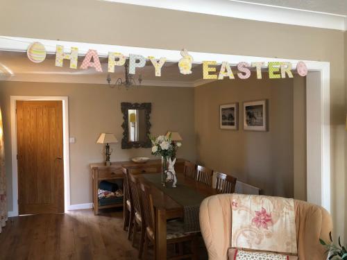 a dining room with a happy easter sign on the wall at Corner Cottage - character, charm, great location. in Ringwood