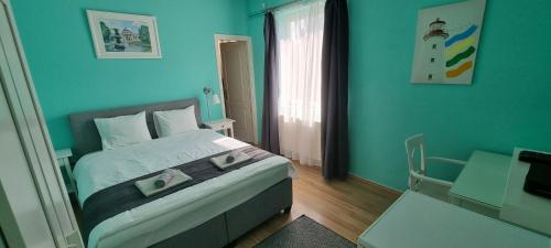 a bedroom with a bed with a blue wall at Joy Guesthouse in Siófok