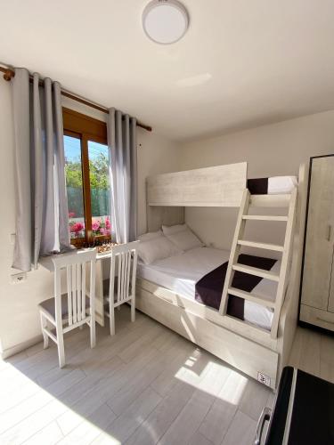una camera con letto a castello, tavolo e sedie di Sunny guest house a Vlorë