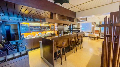 a restaurant with a bar and some tables and chairs at Hotel Schnehagen in Bad Fallingbostel
