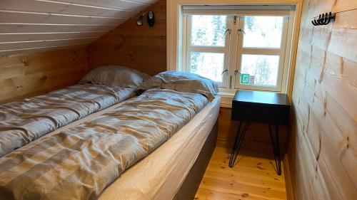 - 2 lits dans une chambre avec une fenêtre et une table dans l'établissement Penthouse by the ski lift, 4 bedrooms, 2 living rooms, à Stranda