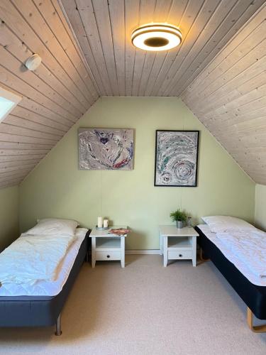 a room with two beds and two tables in it at Lilleledgaard in Ringkøbing