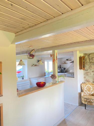 uma cozinha com paredes brancas e um tecto de madeira em Lilleledgaard em Ringkøbing