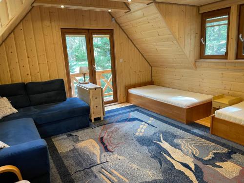 a room with a bed and a couch in a cabin at Domek Żeglarski, Bogaczewo, Jezioro, Warmia, Mazury, Las in Bogaczewo