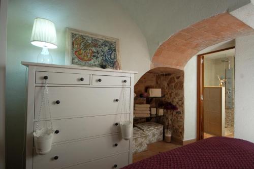 1 dormitorio con cómoda blanca y lámpara en la parte superior en Lets Holidays Tossa de Mar Romantic Apartment, en Tossa de Mar