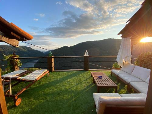 a balcony with a couch and a table and mountains at RIBEIRA SACRA La Imperfecta in Ferreira de Panton