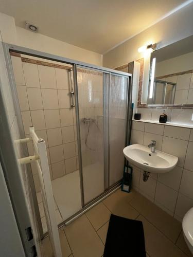 y baño con ducha y lavamanos. en StayHome Apartment Bei Hamburg, en Reinbek